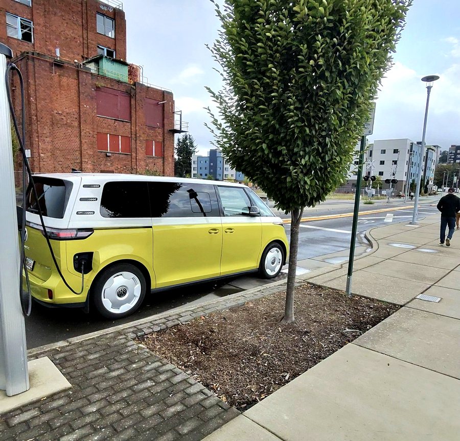 A yellow and white ID. Buzz plugged into a public charging station on a Bellingham street.